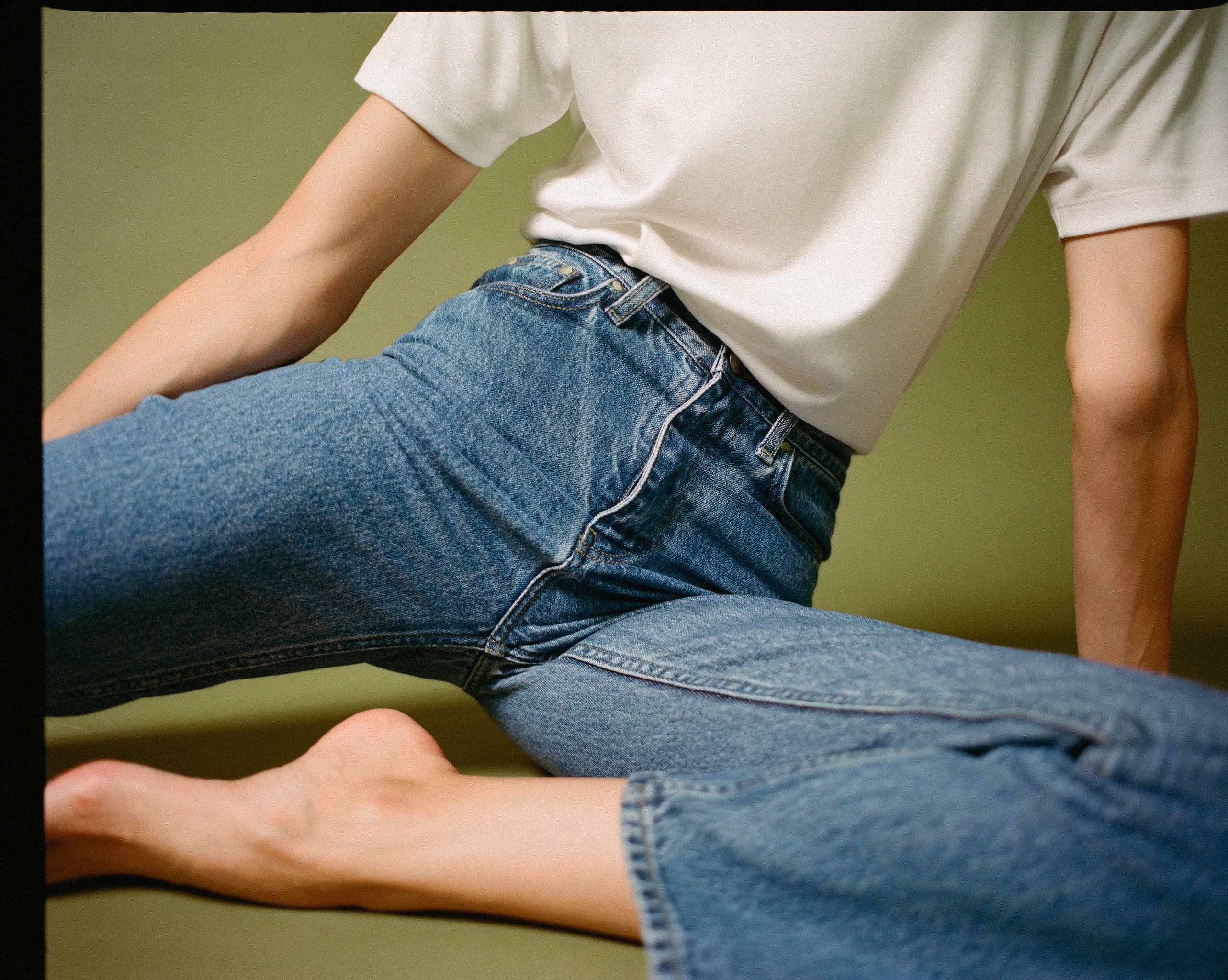 ceinture d'un jean bleu légèrement délavé  porté par une femme