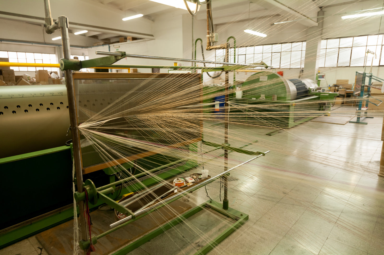 Warp threads moving through a weaving machine in Zanieri’s Prato mill